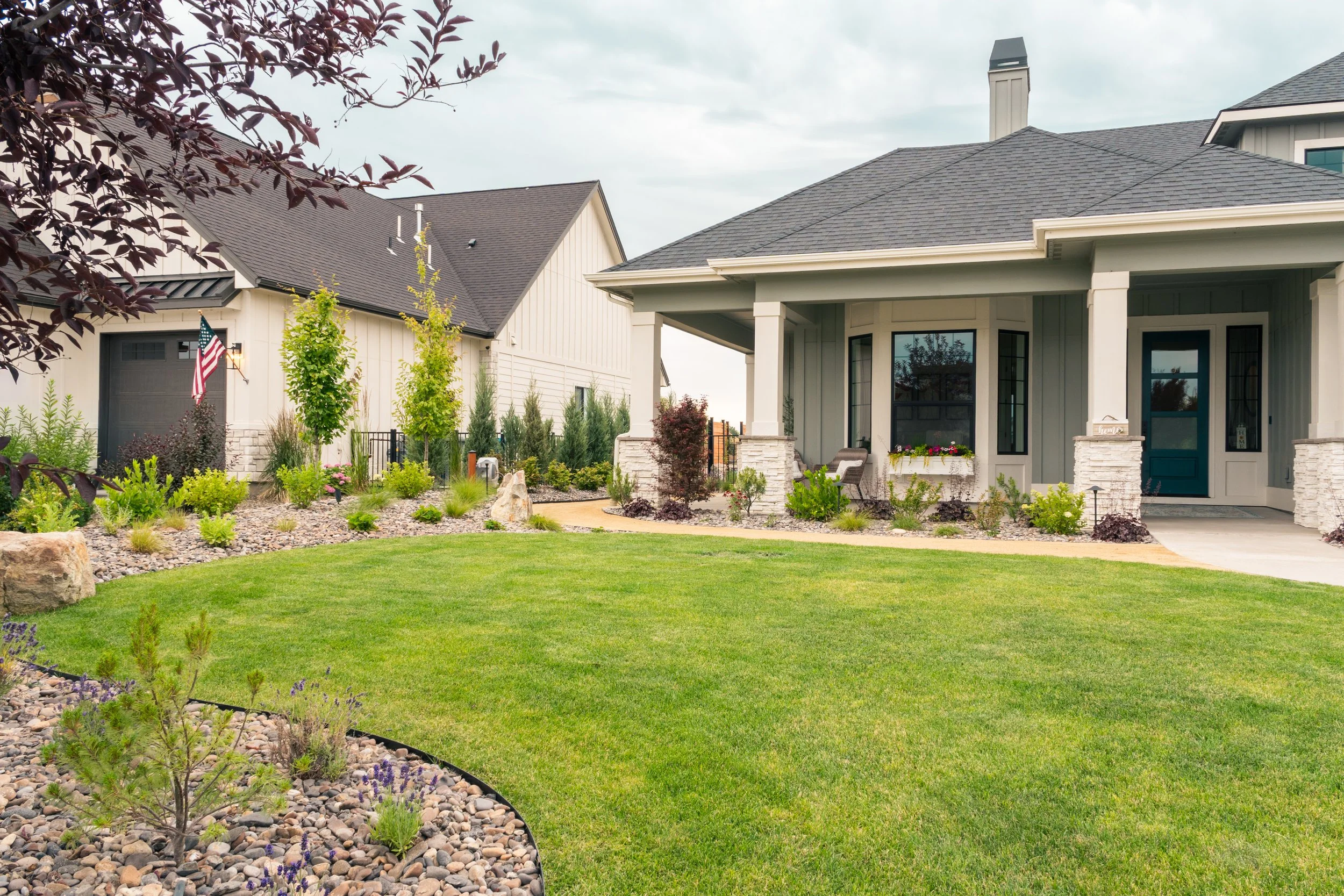 Front view of a thoughtfully designed residential landscape with layered planting, curved walkway, and welcoming entry at a home in Star, Idaho.