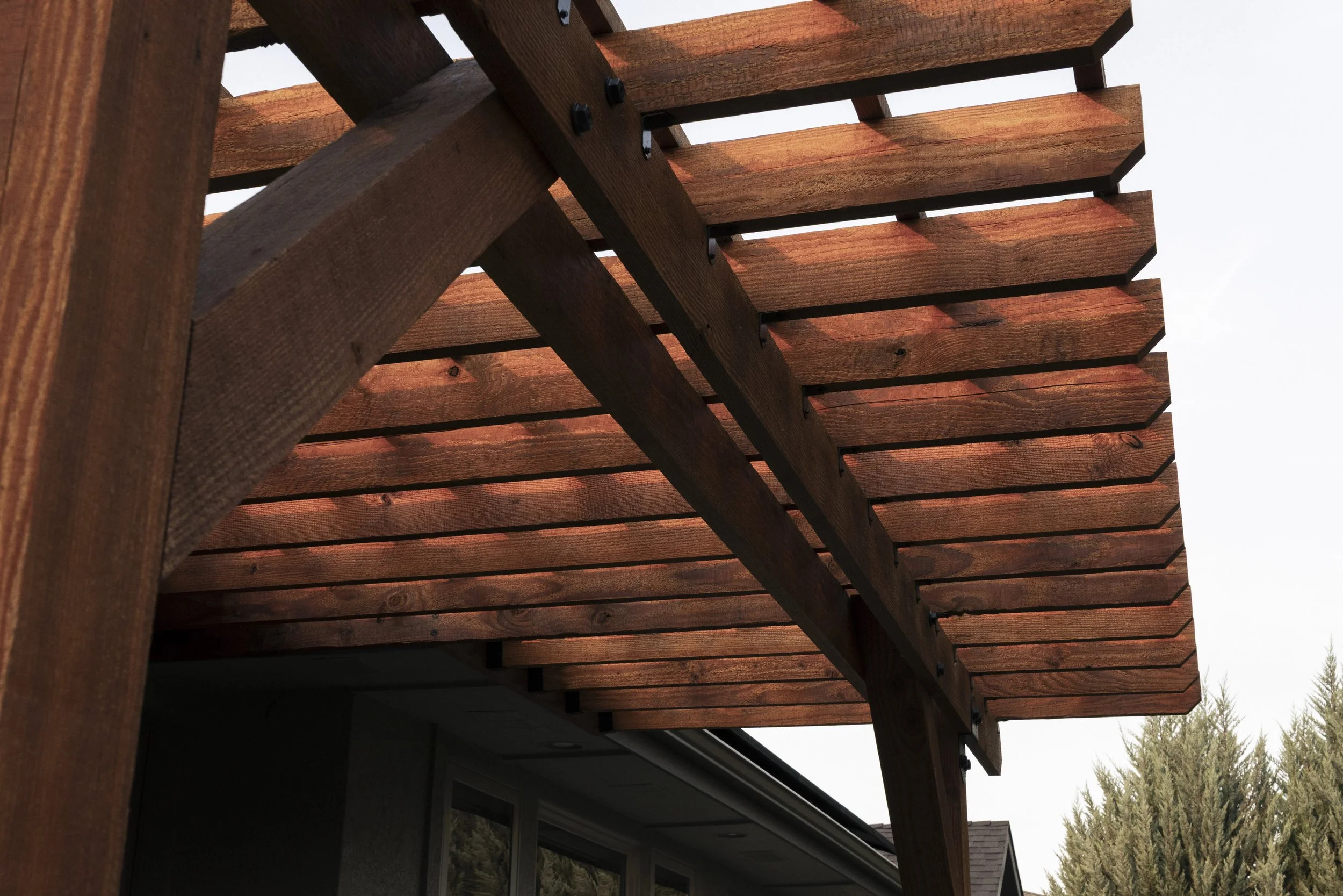 Architectural pergola detail showcasing custom outdoor living design and natural wood craftsmanship in Eagle, Idaho.