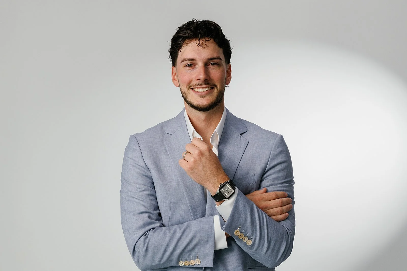 Garrett Wrightson in a light blue suit and white shirt posing against a plain gray background