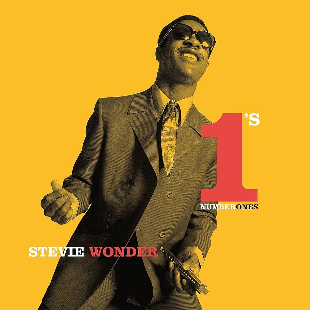 Album cover featuring Stevie Wonder wearing sunglasses and a suit, holding a harmonica, against a yellow background with text that reads "Stevie Wonder's 1st Number Ones."
