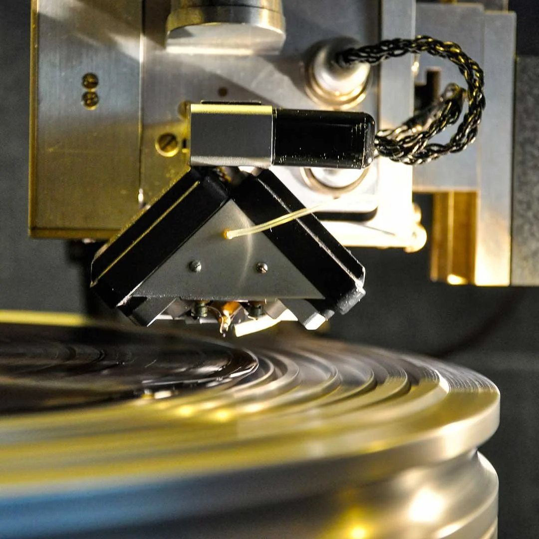 Close-up of a vintage phonograph needle arm and turntable with black vinyl record.