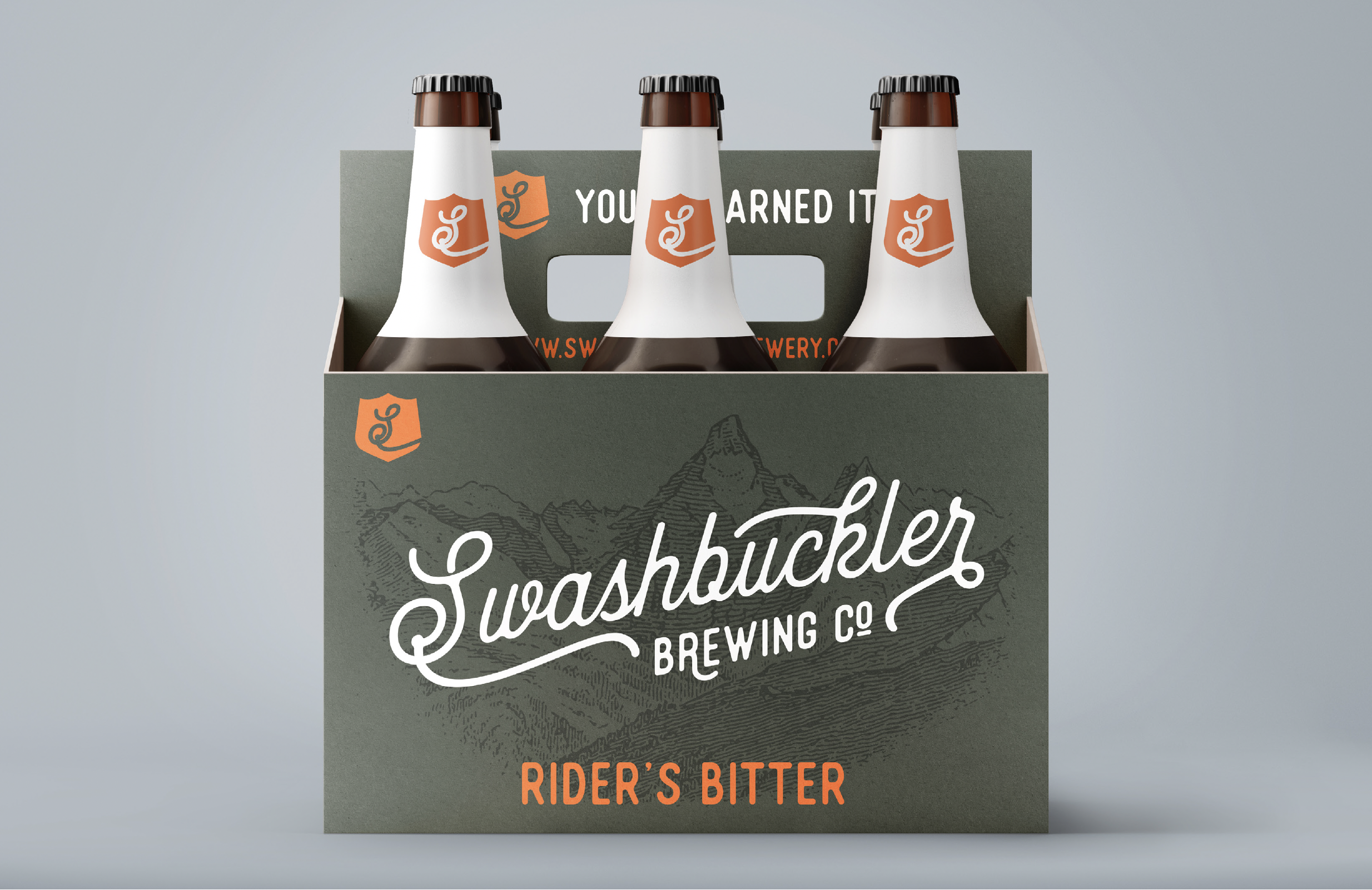 Six bottles of Swashbuckler Brewing Company's Rider's Bitter beer in a six-pack carrier with mountain illustrations and the company's logo on each bottle.