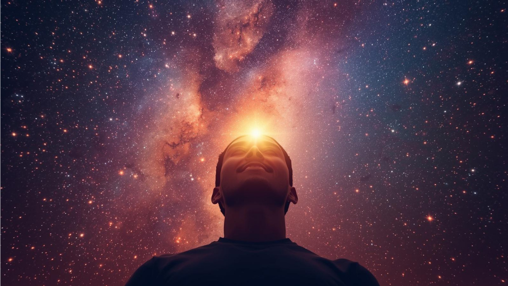 Persona in piedi con la testa rivolta verso l'alto, con un'immagine dello spazio e unaNebula sullo sfondo