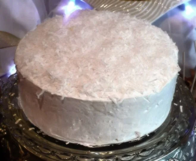 COCONUT CAKE This one's our best seller! We cover four layers of butter cake with fresh grated coconut glaze, and then frost it all with a generous amount of whipped topping and coconut. You might want to get two!