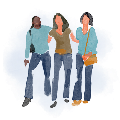 Three women walking together, two wearing light blue jackets and one in a beige top, all with casual jeans.