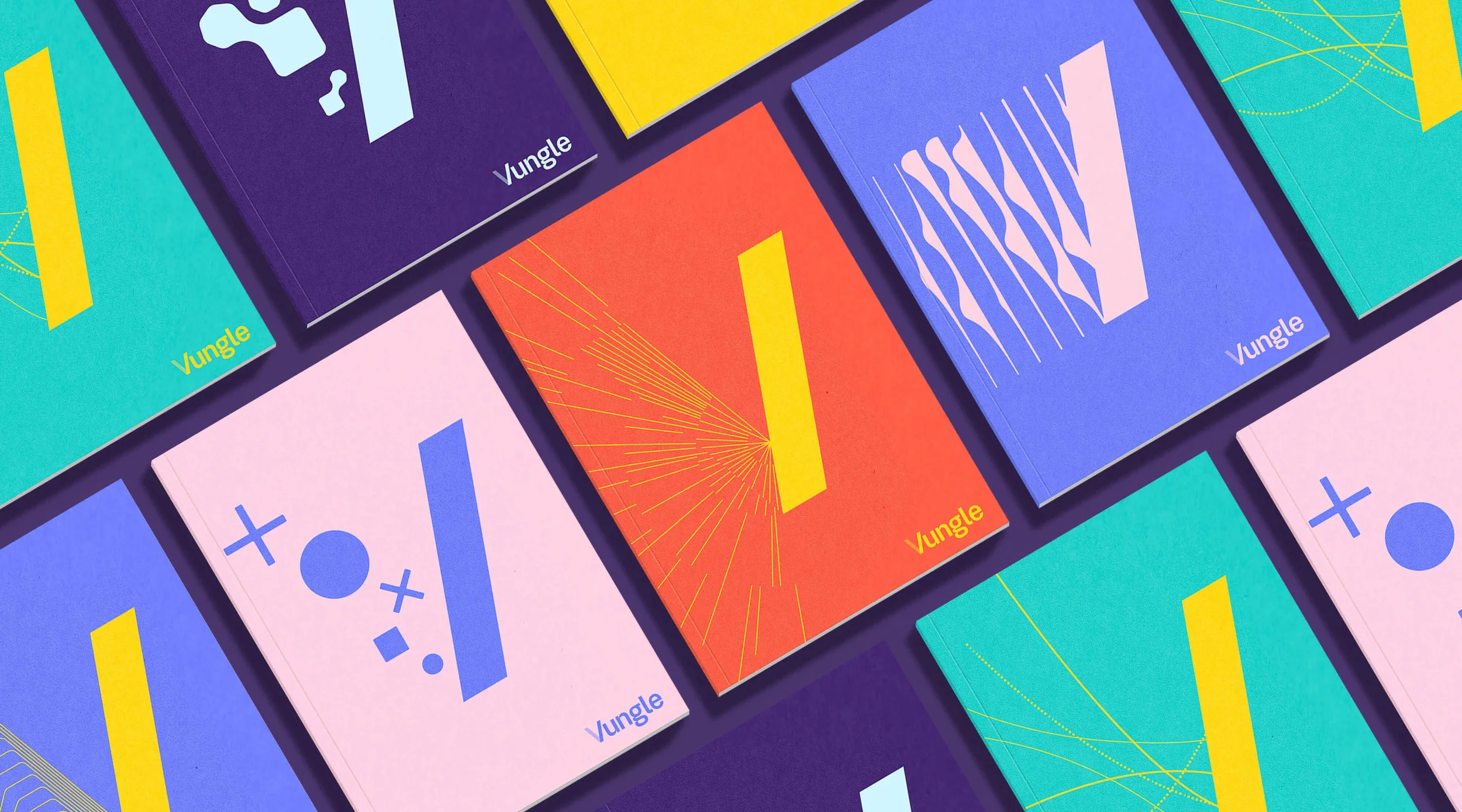 Arrangement of colorful books with abstract geometric cover designs in a grid pattern. The books have various background colors including turquoise, purple, pink, orange, and blue, with the word "Vungle" printed on some covers and minimalistic graphi