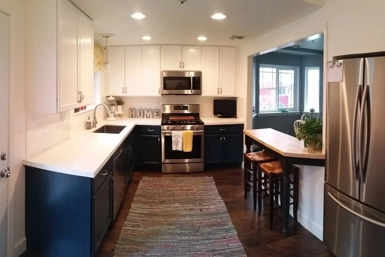 This kitchen transformation included new cabinets, countertops, and flooring, plus relocating the refrigerator into the wall to create a cleaner, more functional space.