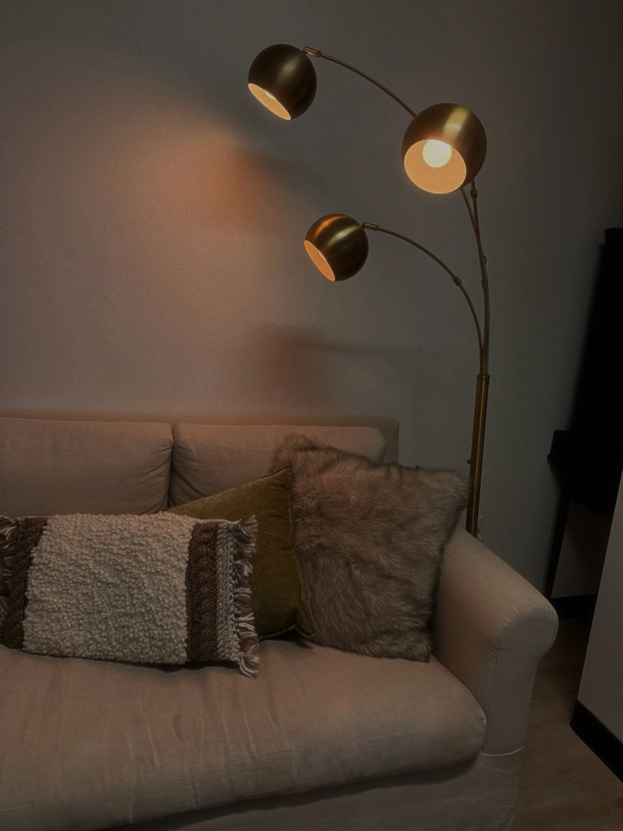 A three-light lamp is turned on in a well-decorated room, enhancing the space's atmosphere