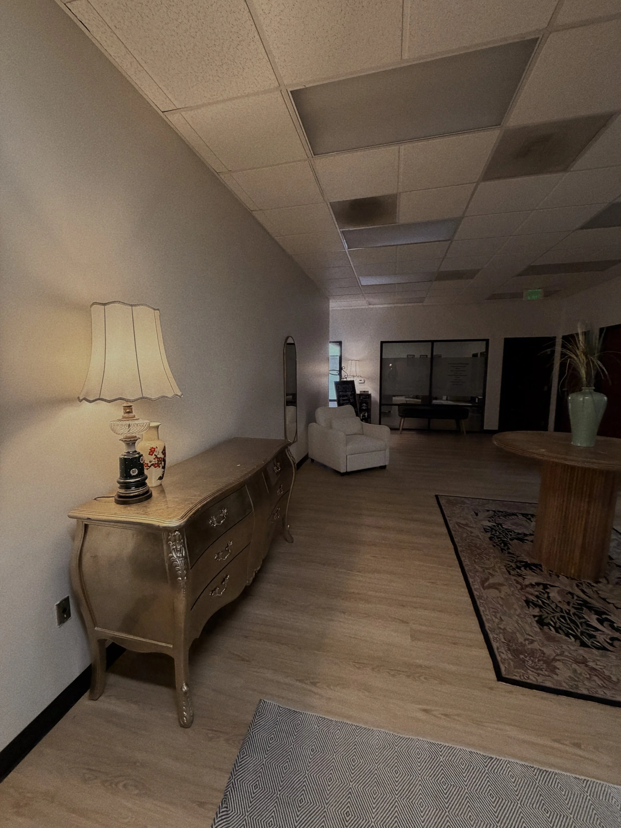 A room featuring a table and a lamp placed on the floor, creating a cozy and inviting atmosphere.