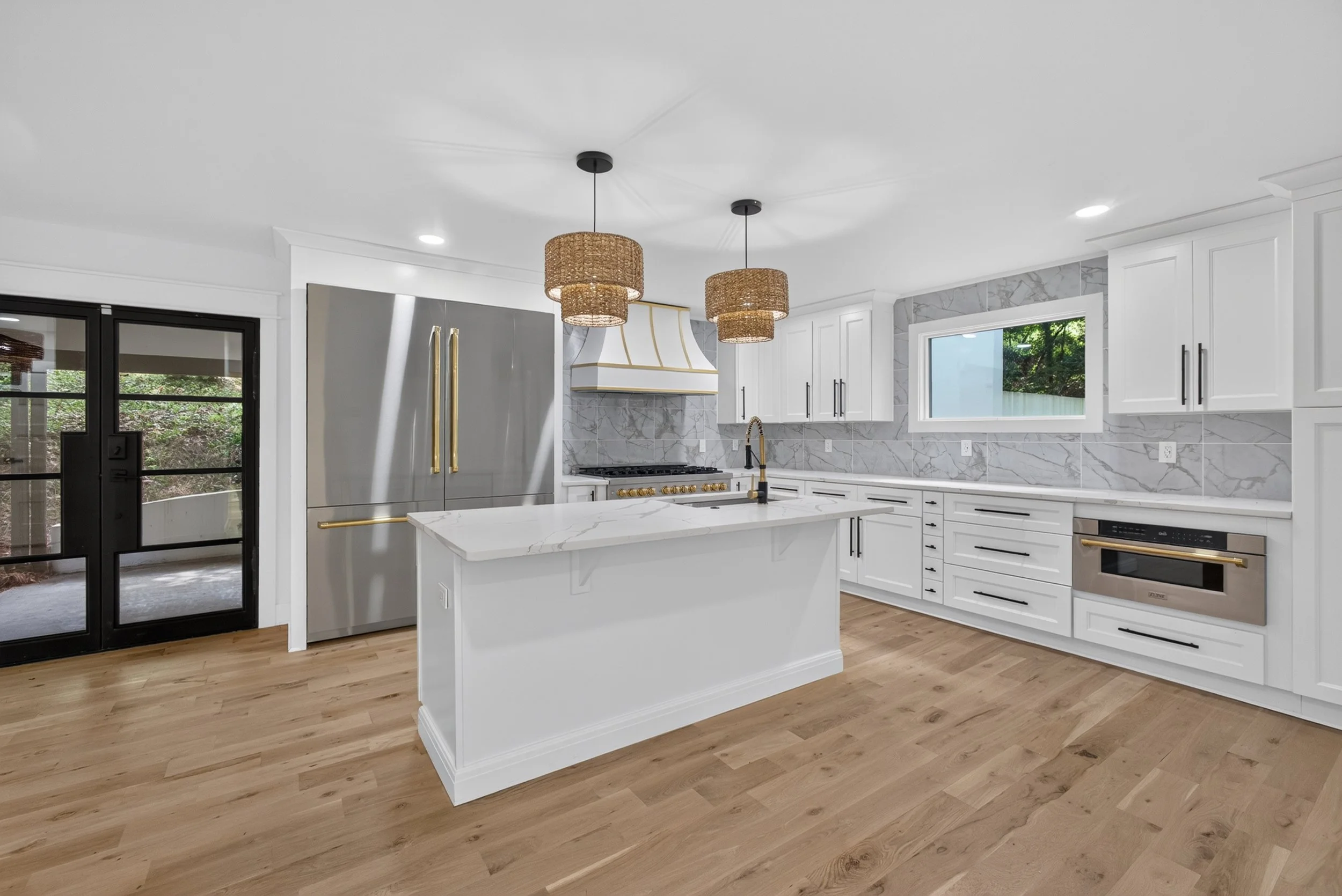 Modern kitchen interior with white cabinetry, marble island, and pendant lighting, real estate photography by Foundation Media Group