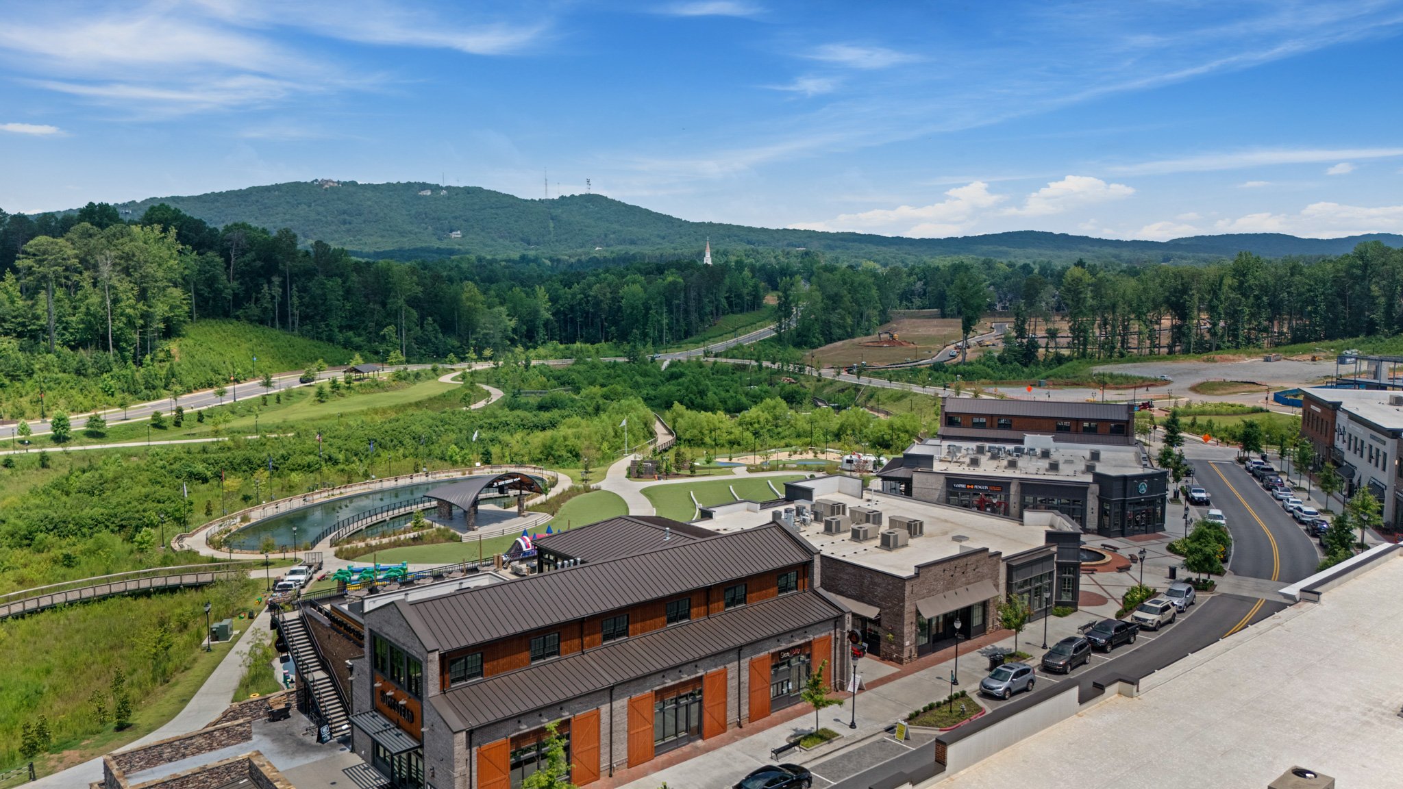 Aerial drone photo of a mixed-use commercial development with buildings, parking, and green space, FAA Part 107 certified aerial photography by Foundation Media Group