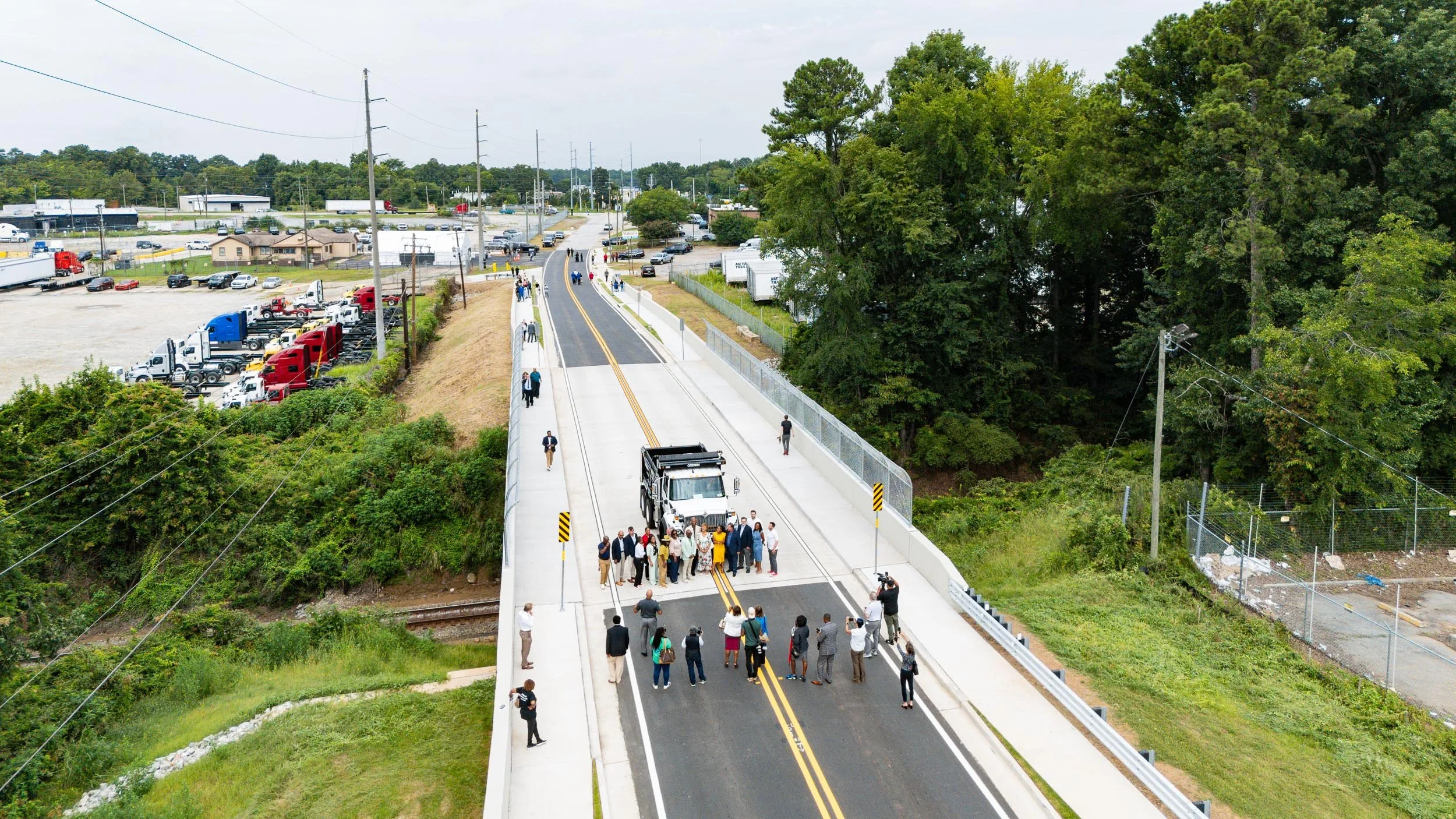 Aerial drone photo of a ribbon-cutting ceremony on a newly completed roadway, FAA Part 107 certified aerial photography by Foundation Media Group