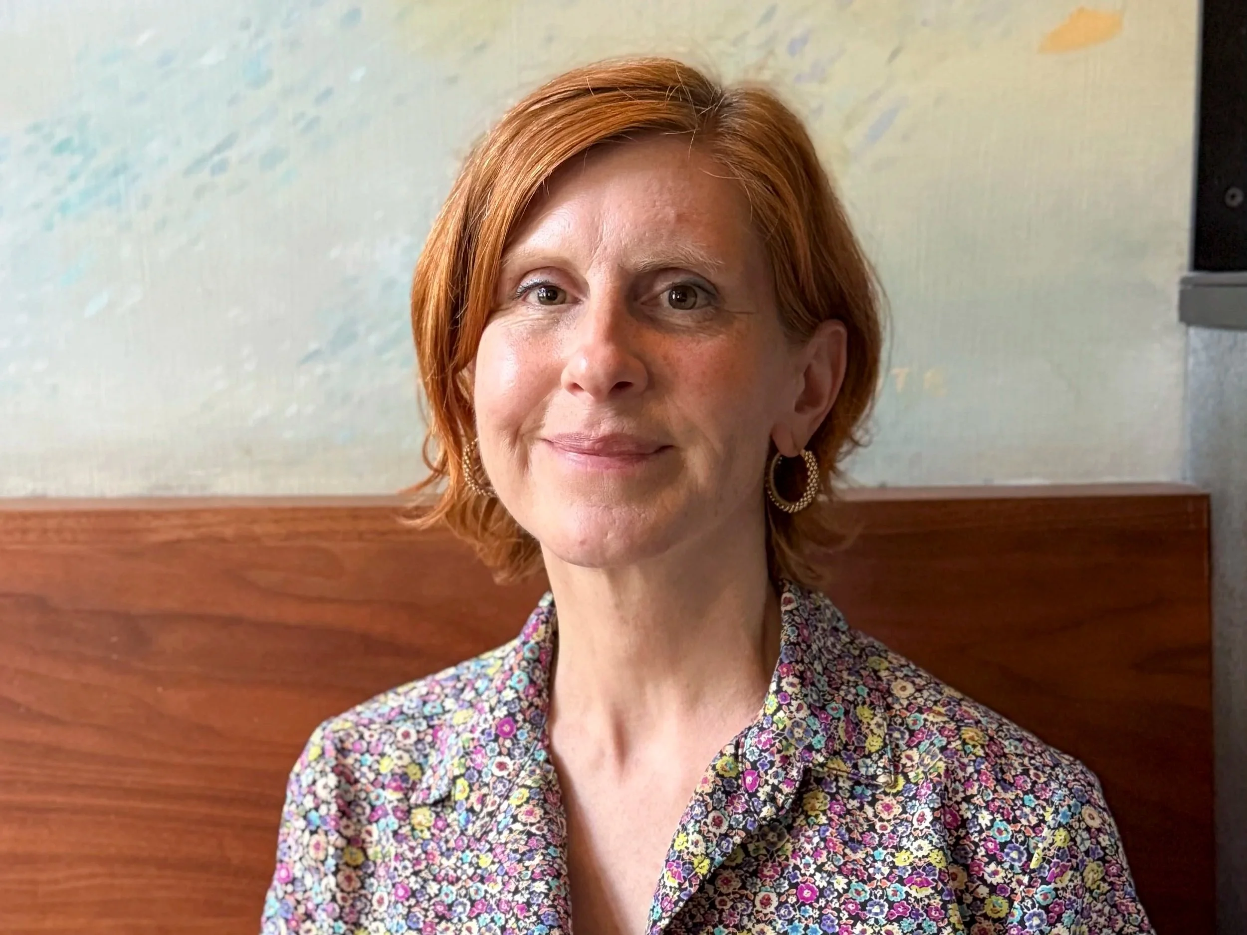 Portrait of a woman with short red hair.