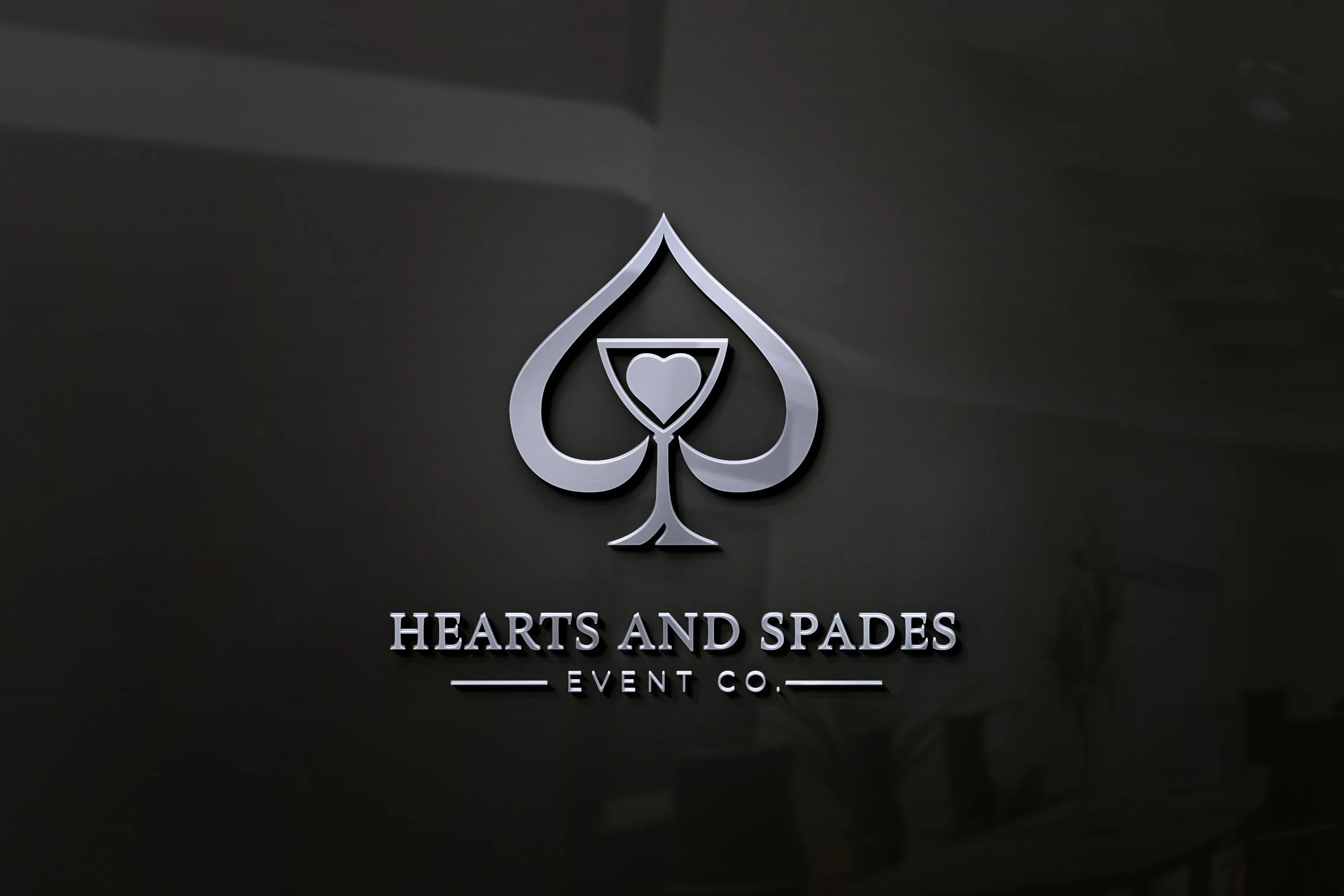 Metallic logo of a spade with a heart inside, with the text 'Hearts and Spades Event Co.' underneath, on a dark background.