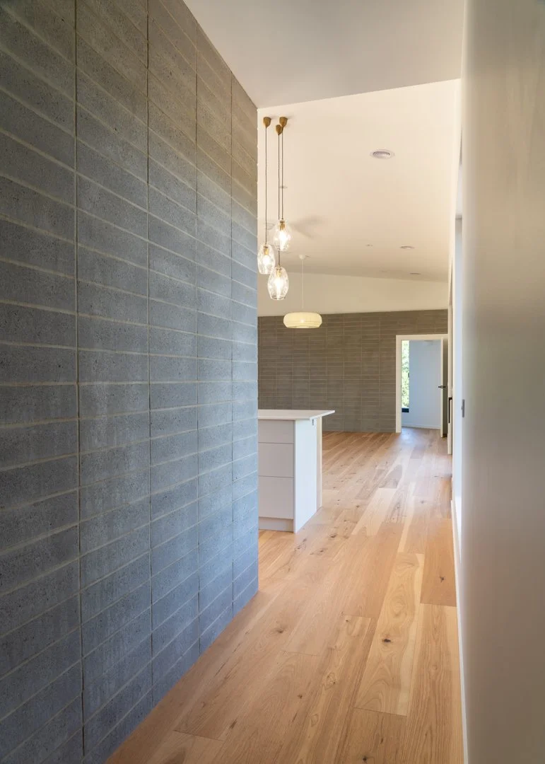 photo lookimg down hallway of house into kitchen with green walls