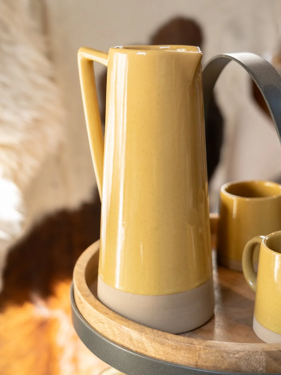 Yellow jug and mugs sitting on table
