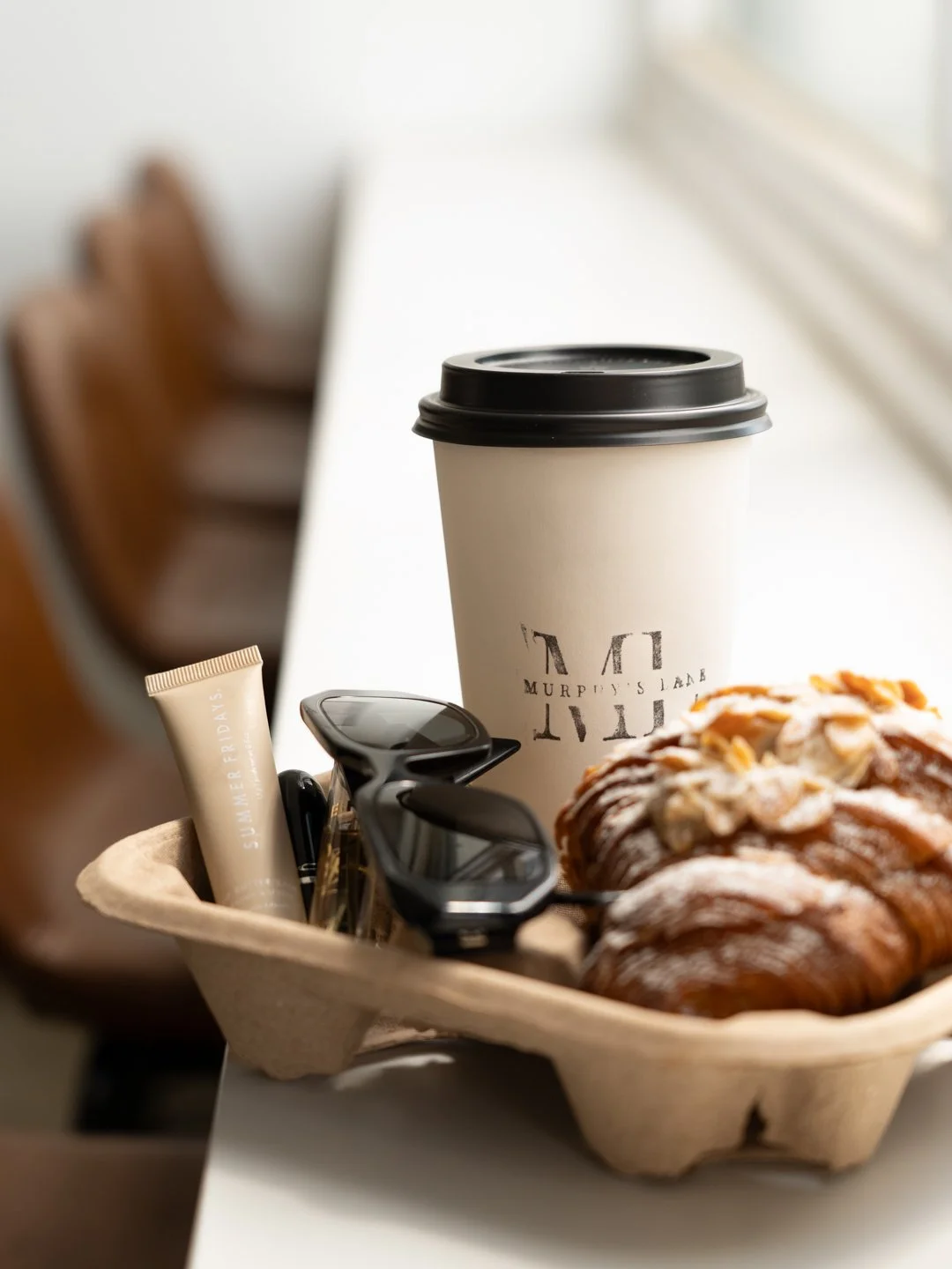 Croissant, coffee and sunglasses sitting on table