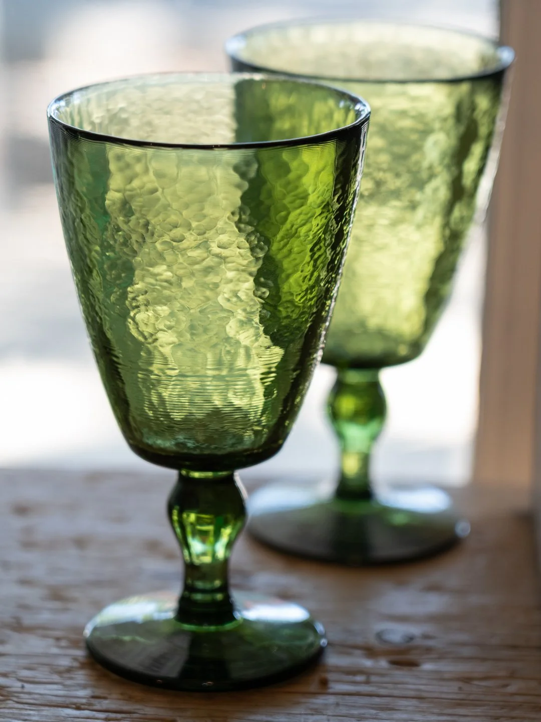 Green wine glasses sitting on table