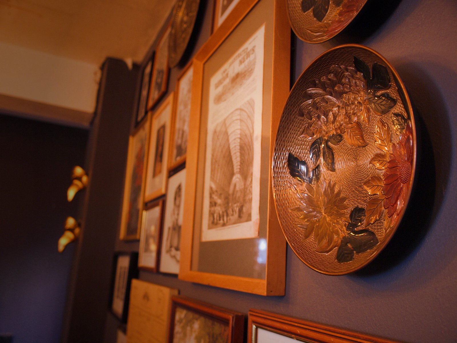 Decorative circular glass plate with floral and leaf patterns on a shelf.