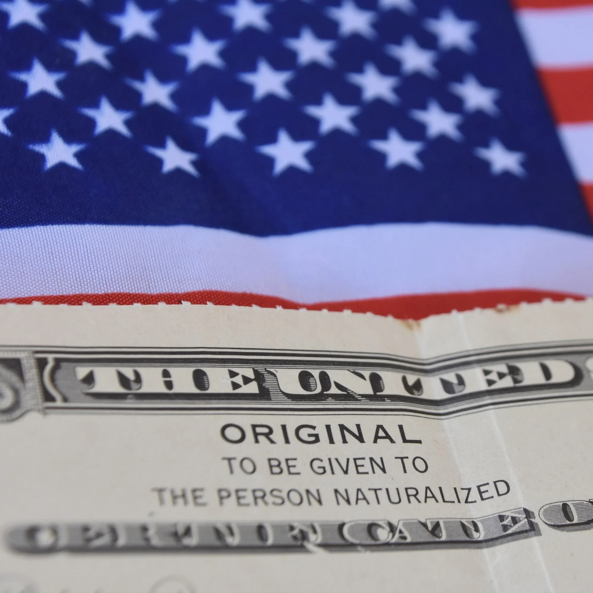 Close-up image of a U.S. flag and part of a one-dollar bill.