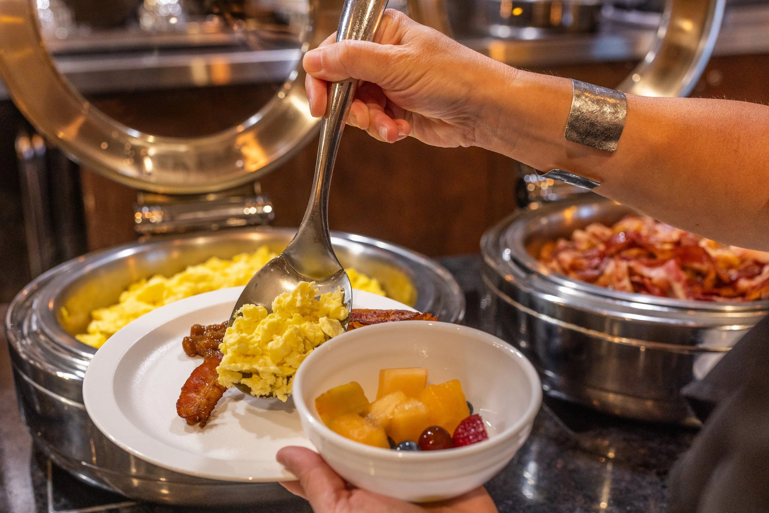 Free Breakfast at Best Western Plus Chocolate Lake. A person making a breakfast plate at Best Western Plus Chocolate Lake's complimentary hot breakfast buffet. Free Breakfast.