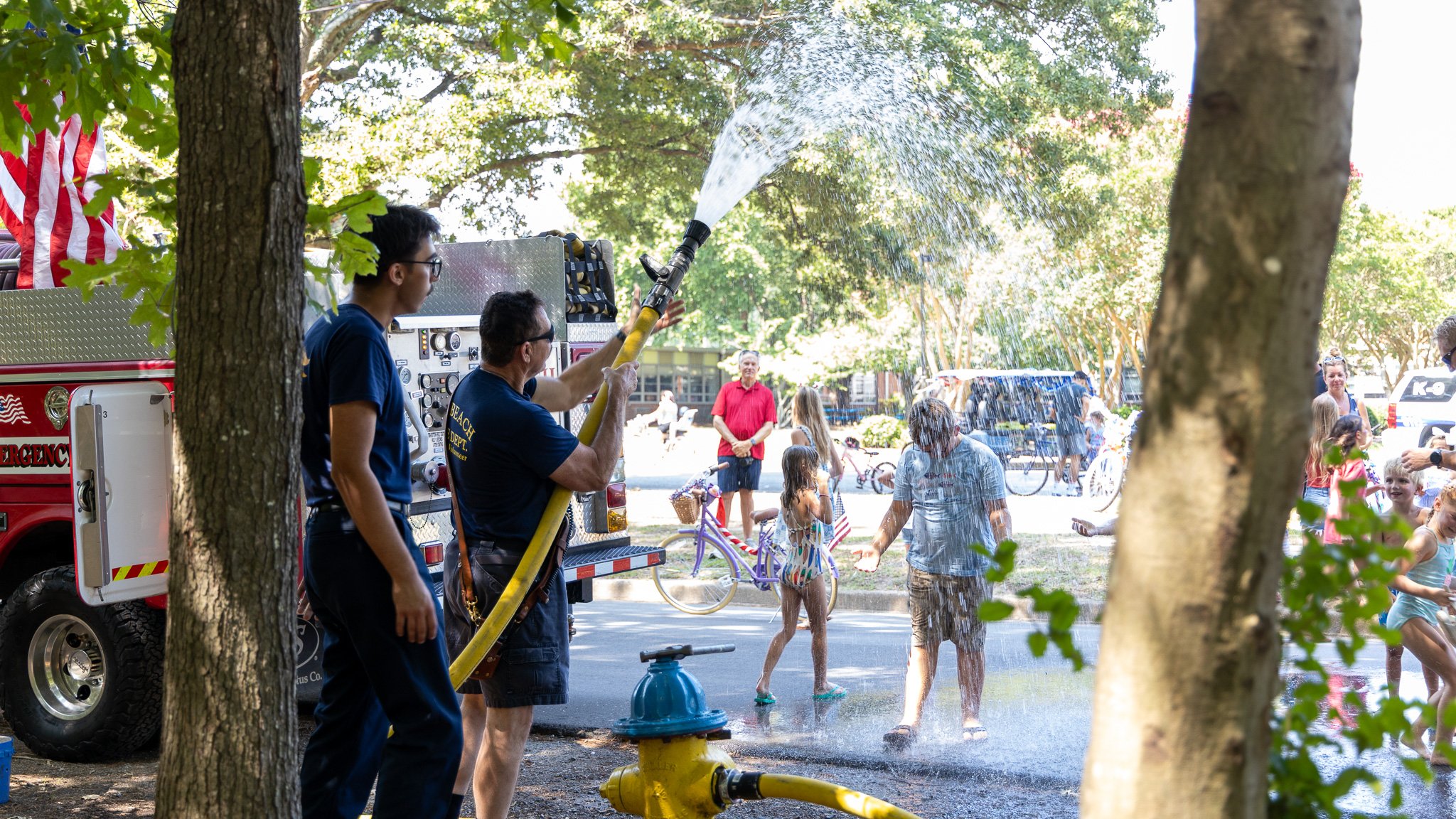 Virginia Beach, Virginia, 4 July 2026 -- Heat Wave: Kennedy showers the paraders of Alanton with water from a nearby fire hydrant. Photo: Jesse Ankney.