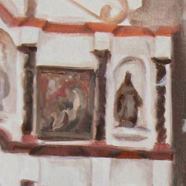 A close-up of a decorative wall with small niches and religious statues or icons.