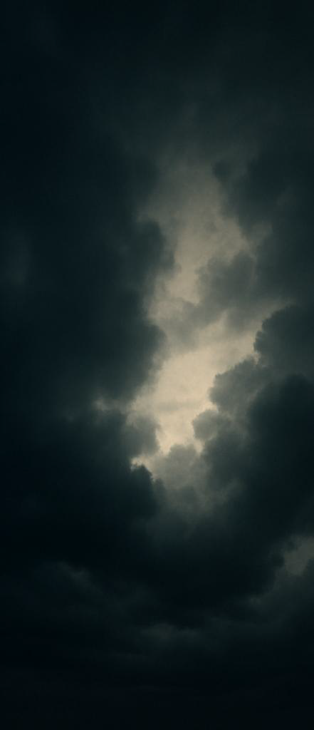 Dark stormy clouds over a cloudy sky with light breaking through