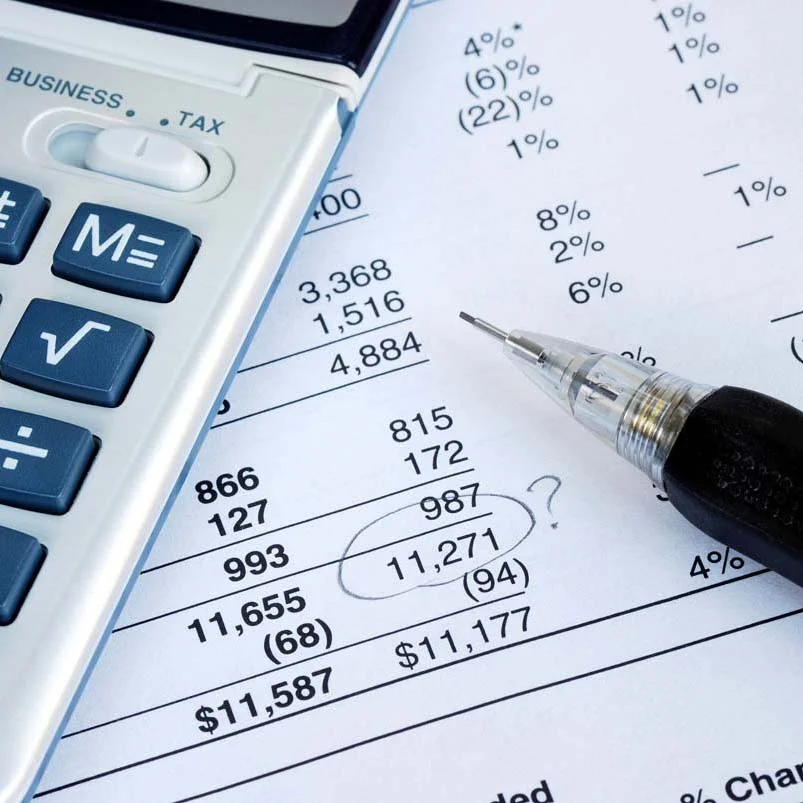 Financial documents with numbers, percentages, and calculations, accompanied by a calculator and a pen.