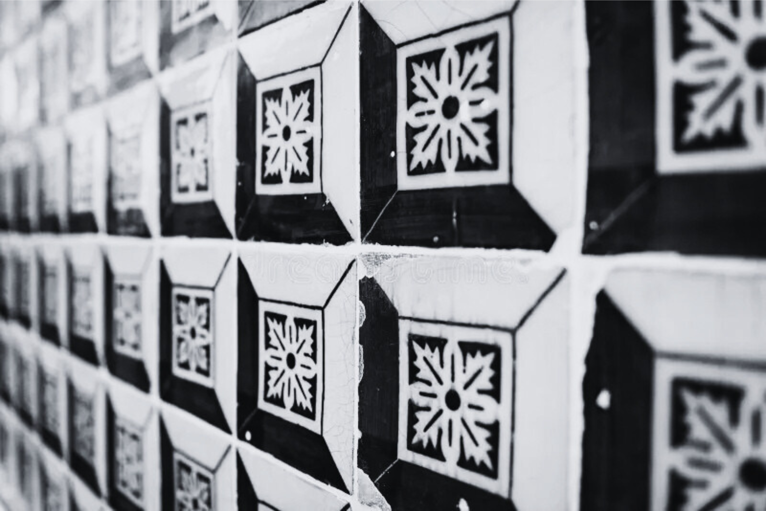 black and white photo of old tiles along a wall