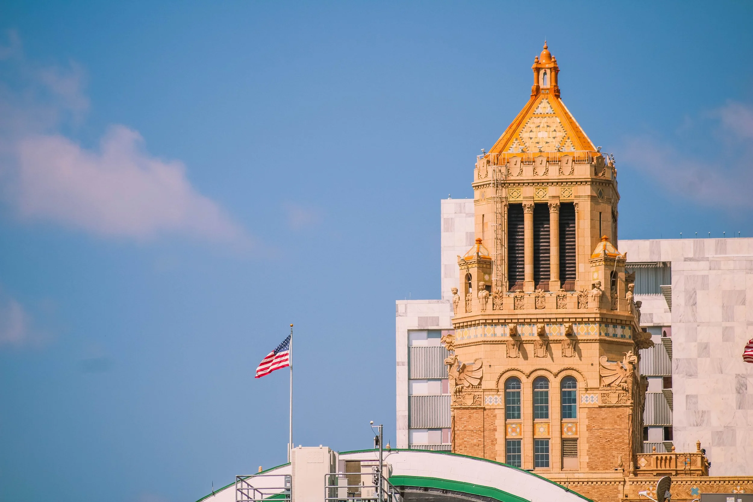 Mayo Clinic, Rochester, Minnesota. Close-up of a historic Plummer building with ornate architectural details, and a spire, against a clear blue sky with a few clouds and Gonda building.