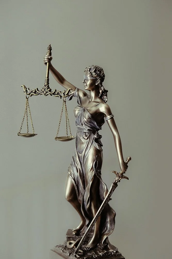 Statue of Lady Justice holding scales in her left hand and a sword in her right hand.