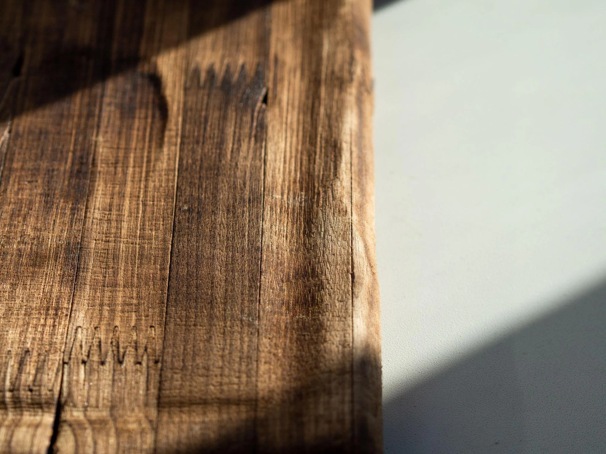 Close-up of a weathered wooden surface with visible grain and texture