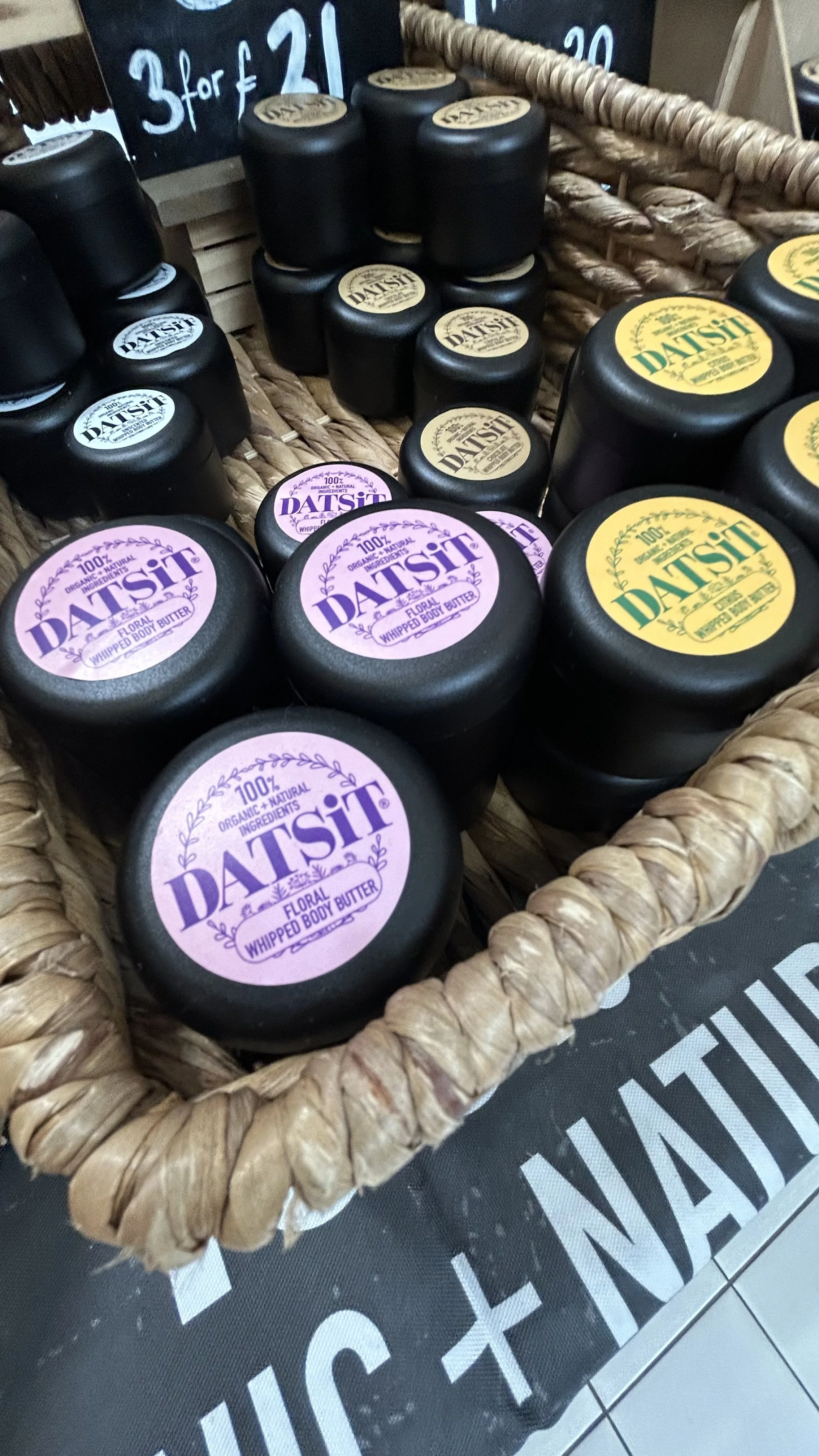 Basket containing jars of Datsit floral whipped body butter with purple and yellow labels.