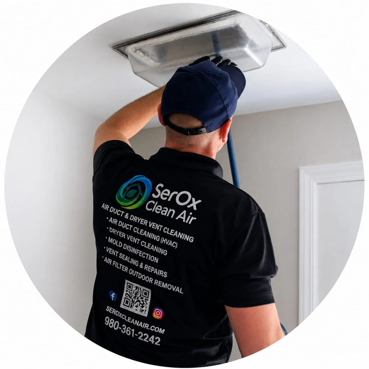 A man wearing a face mask and black gloves using a red vacuum hose to clean an HVAC vent in a ceiling.