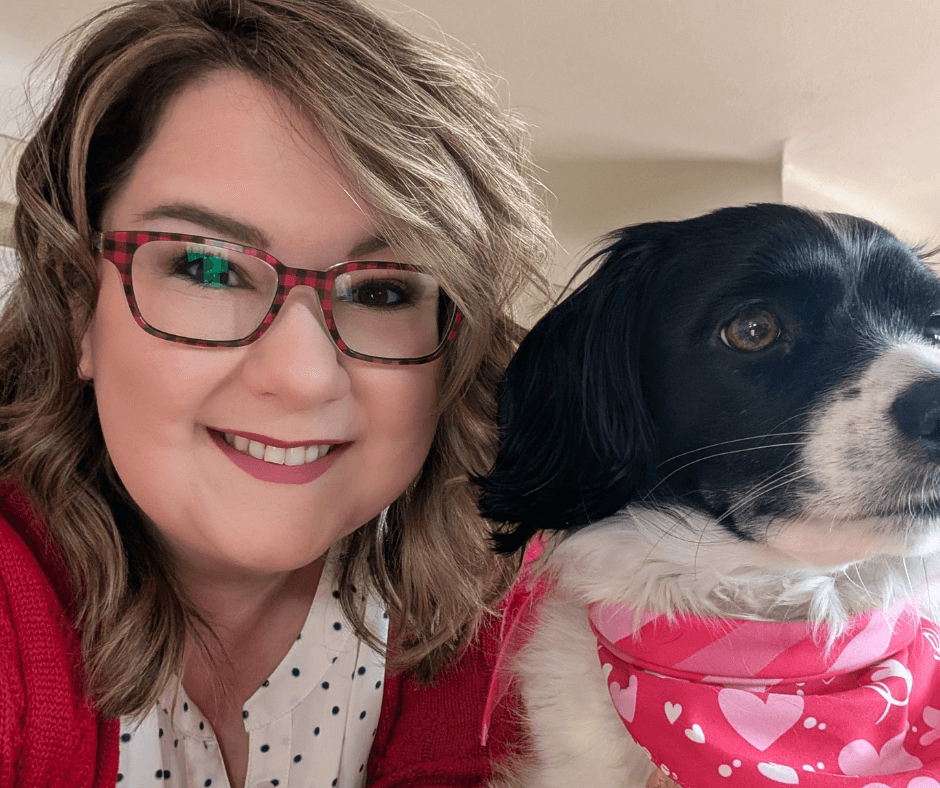 girl in glasses with black and white spaniel mix wearing bandana