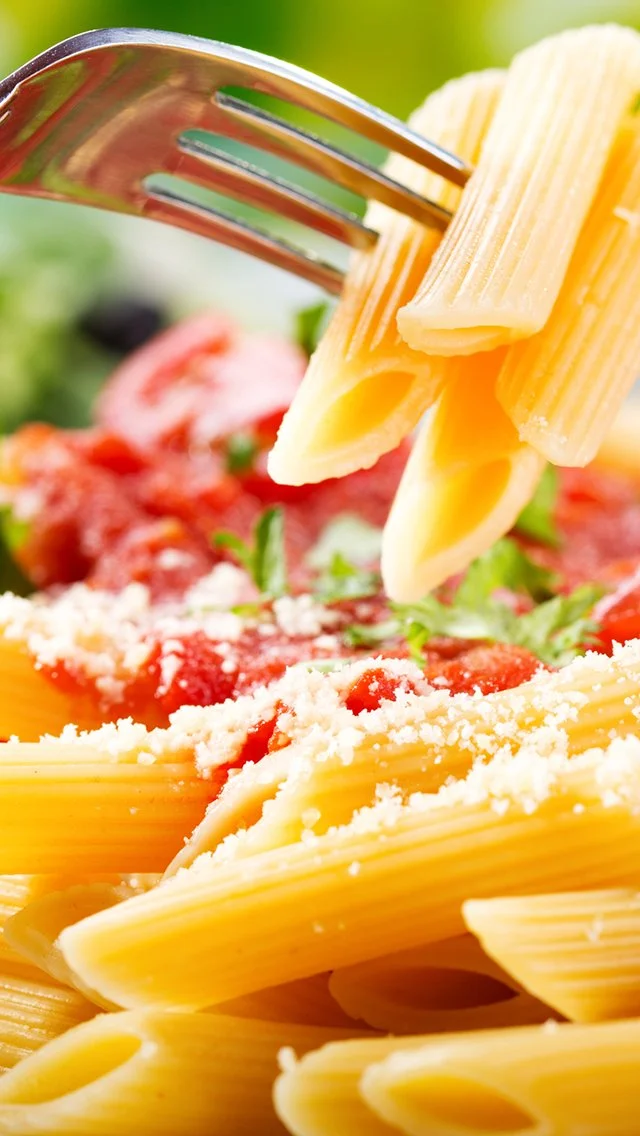 Close-up of uncooked spaghetti pasta with tomato sauce, grated cheese, and fresh herbs.