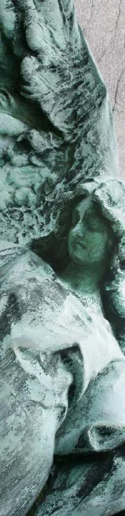 Close-up of a weathered, patina-covered sculpture of a winged angel.