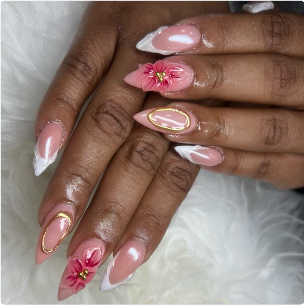 Manicured fingernails with pink, white, and gold nail art, including floral designs and 3D flowers.