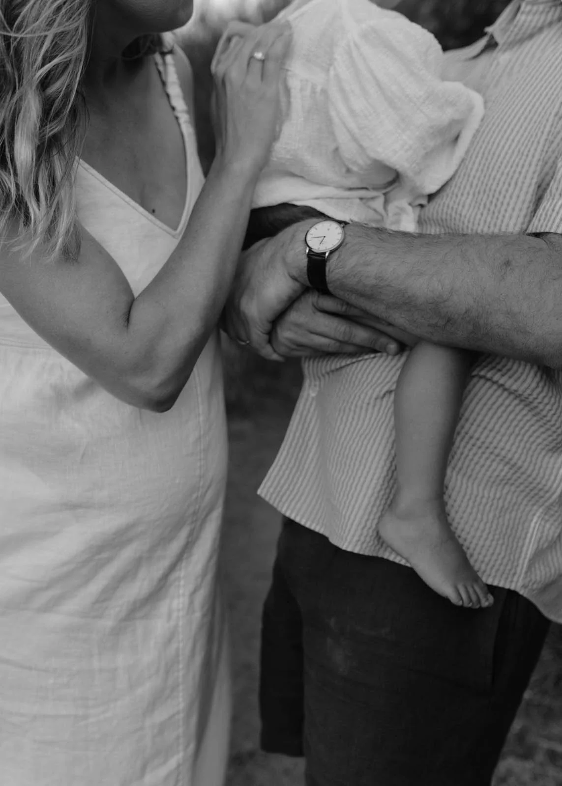 gold-coast-family-photographer-parents-holding-child-close.jpg