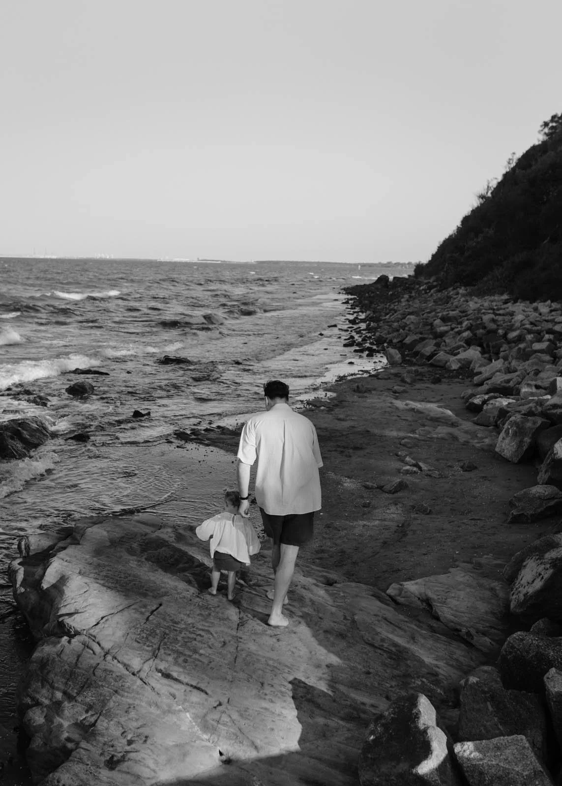 gold-coast-family-photographer-father-helping-child-near-water.jpg