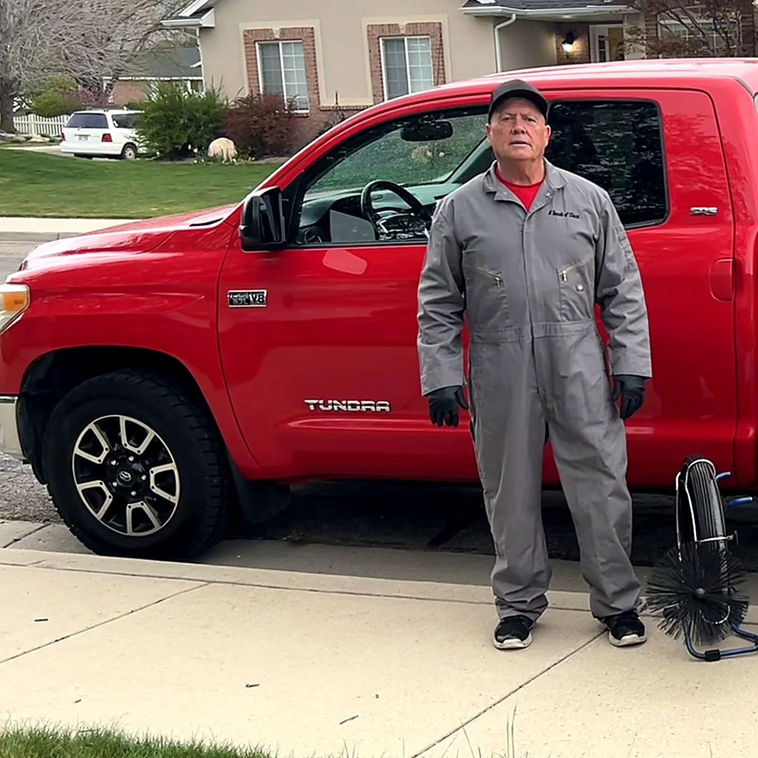 Jim Gueck of A Touch of Class Chimney Sweeps standing with his service truck and chimney brush in Springville, Utah