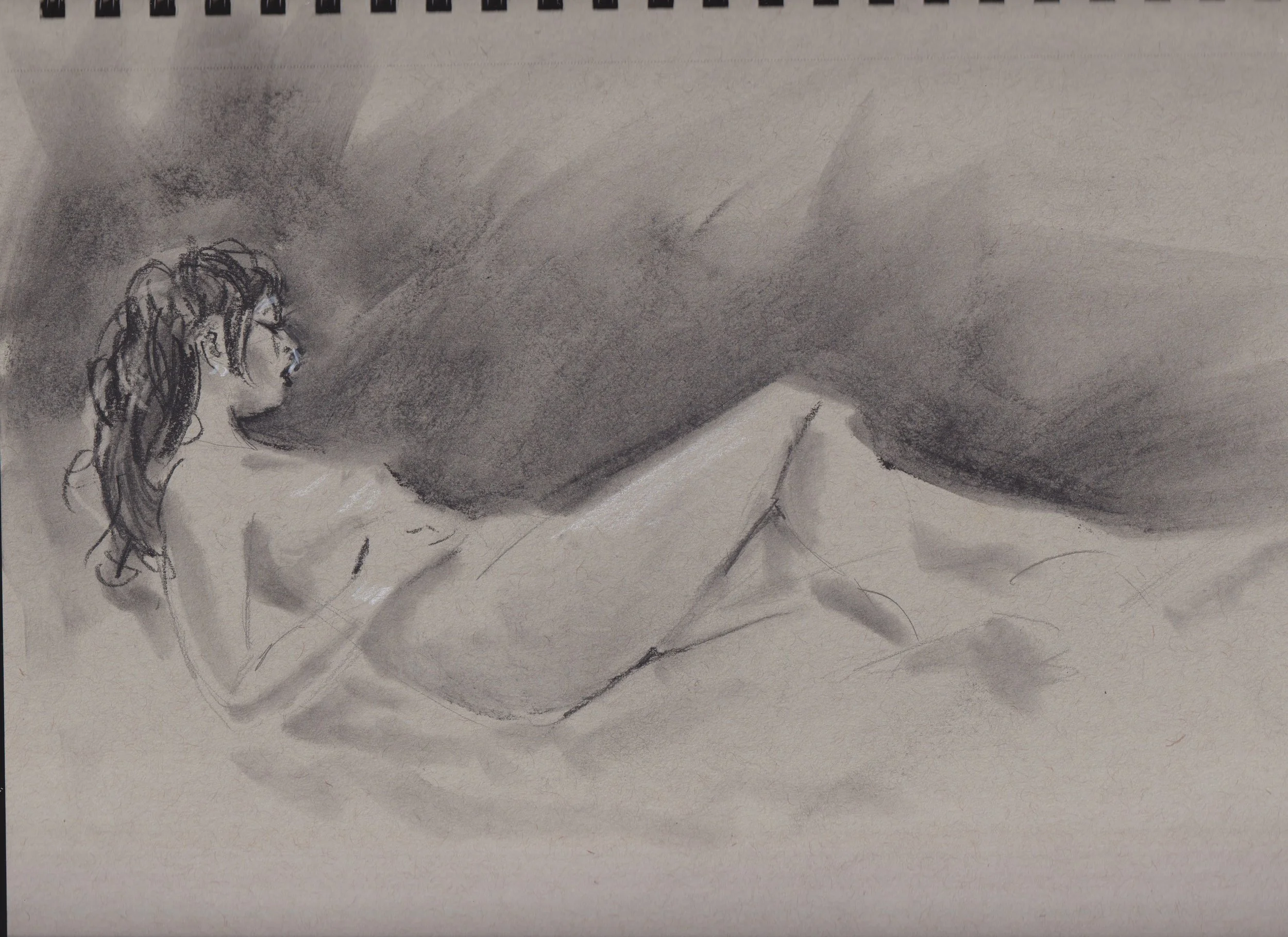 A black and white sketch of a woman lying on her side on a bed, with her upper body propped up. She has wavy hair and glasses, and appears to be looking to her left.