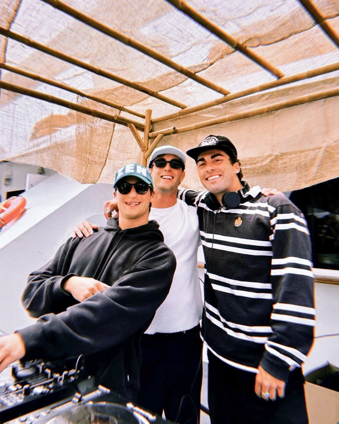 The 3 co-founders of The Groove Events, Noah Zwartendijk, Owen Solomon, and Corbin Mason together at their boat party in San Francisco. They are standing behind the DJ booth.