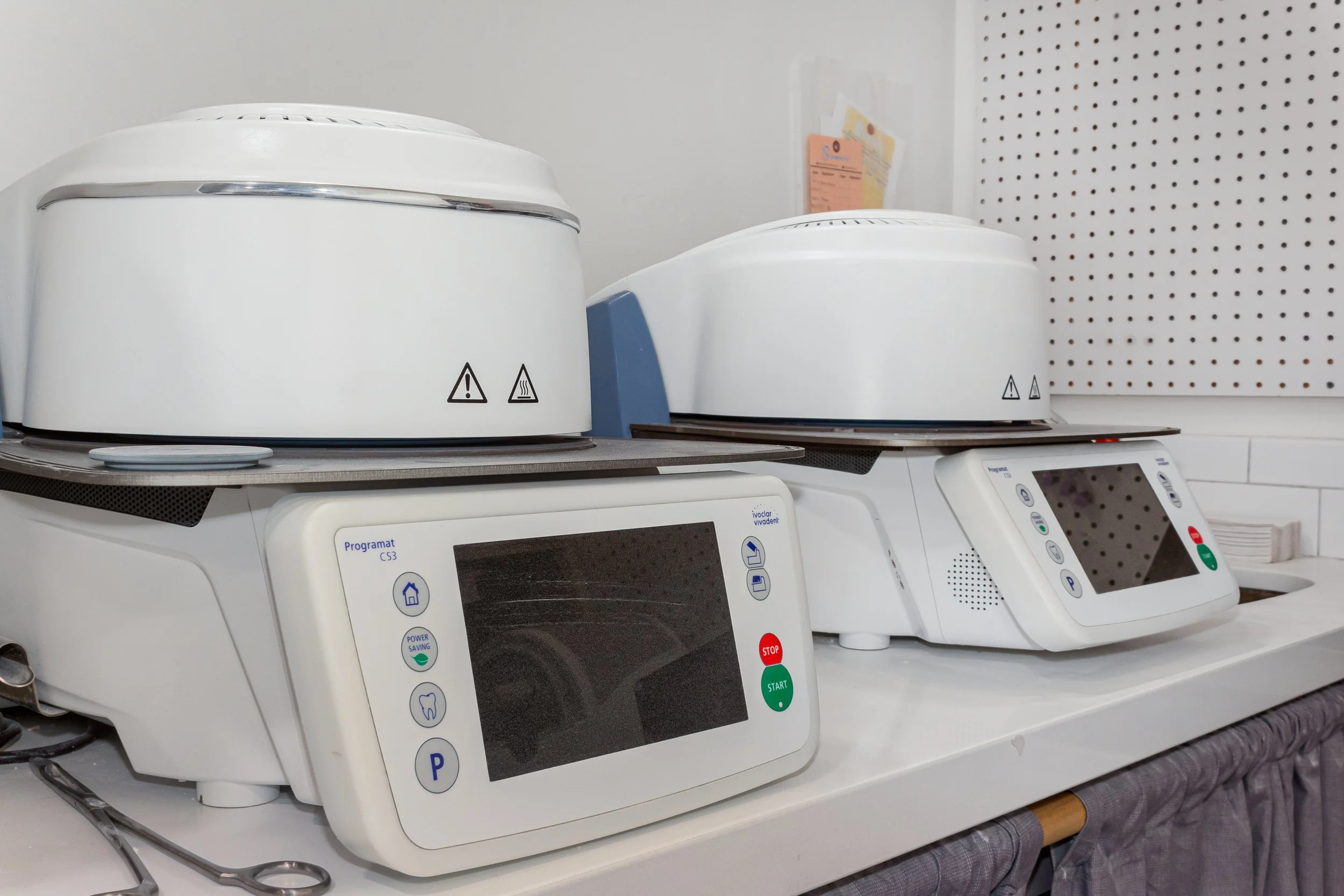 Multiple dental or medical sanitizing ultrasonic cleaning machines on a counter in a clinical setting.