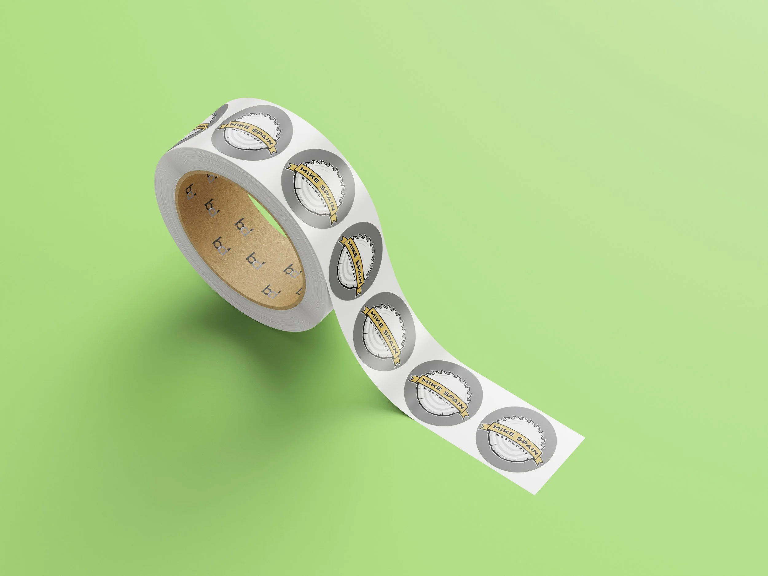 Photo of roll of round stickers with Mike Spain Woodworks full color logo