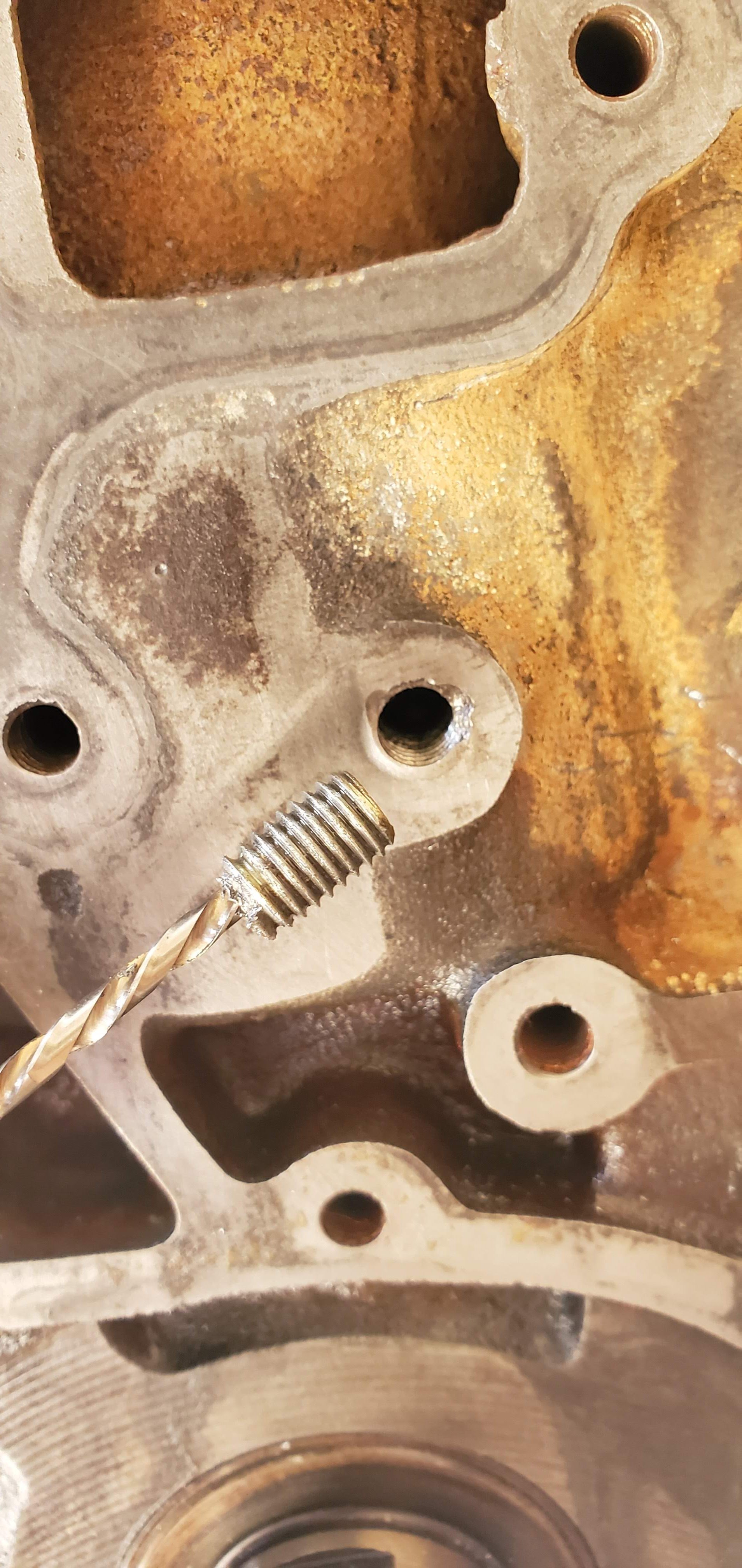 Close-up of a successfully extracted tension bolt from a Nissan CA20E engine block.