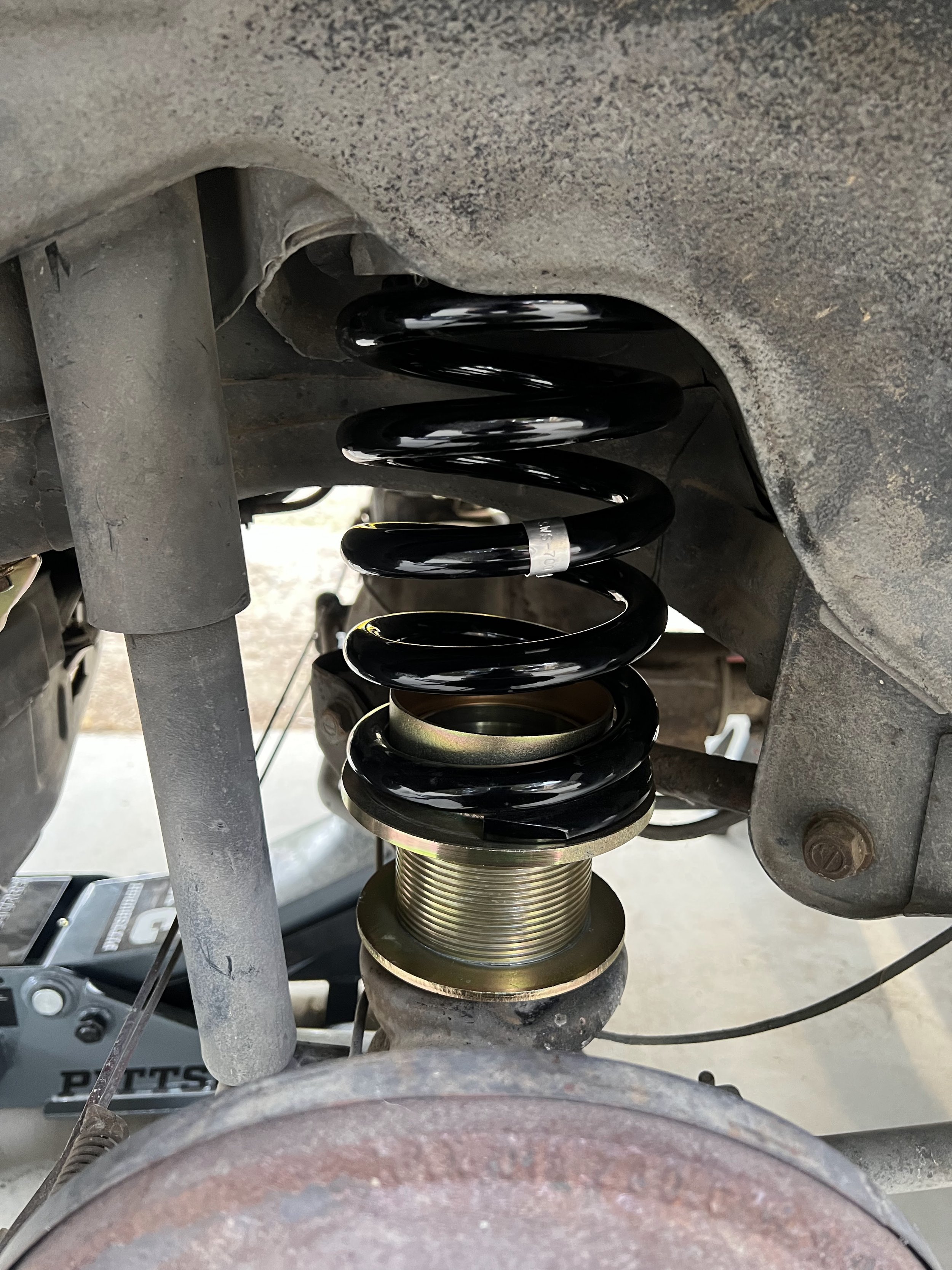 Close-up of a new rear lowering spring and spring perch on a 1984 Nissan 200SX S12.