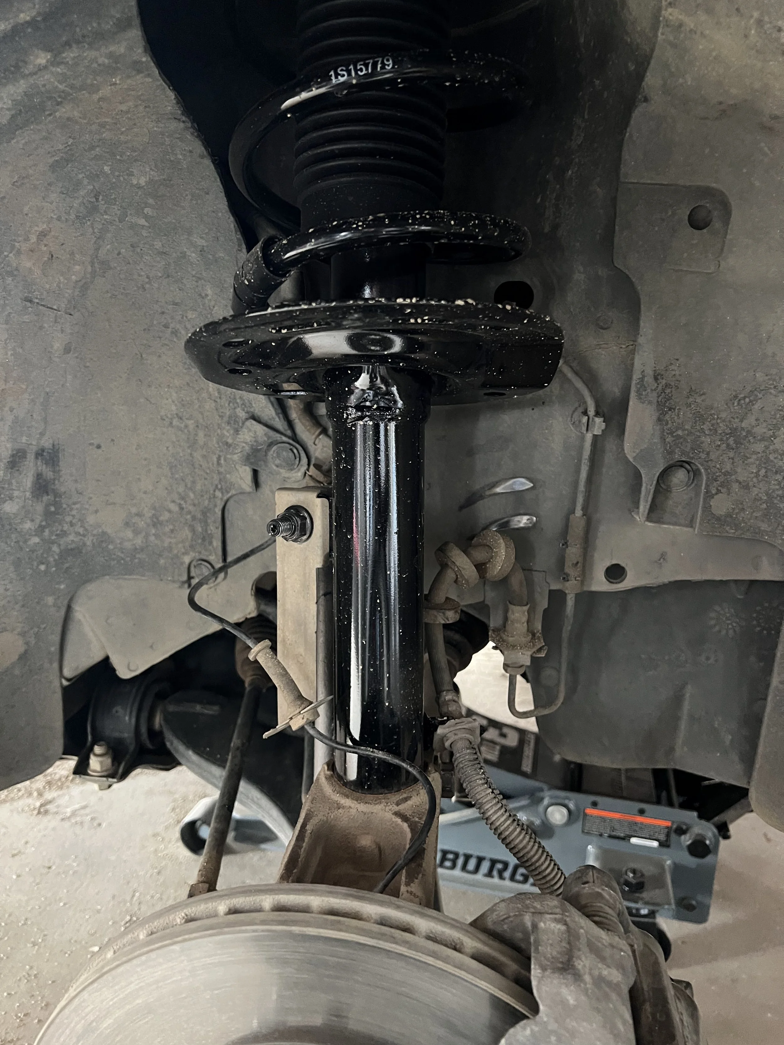 Overview of a 2010 Ford Focus SE front suspension with a new shock assembly and new end link.