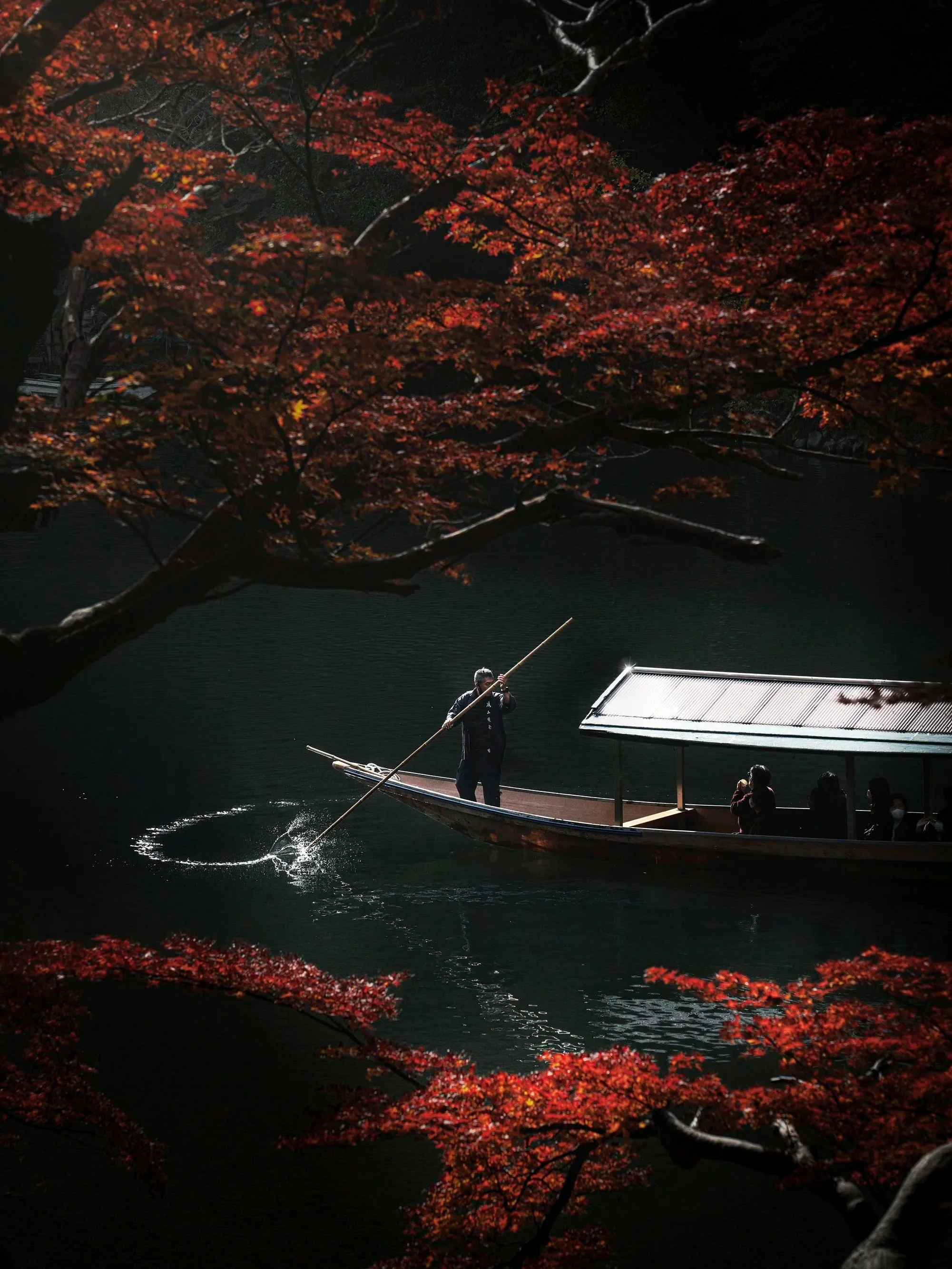 A tekogi bōto on a Japanese river gliding with travelers in iconic places to experience a meaningful, intimate, and unforgettable travel experience in Asia, Japan, Kioto.